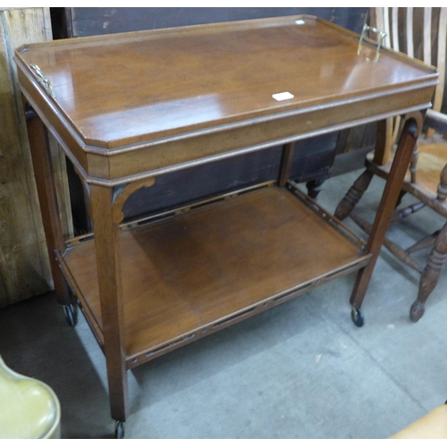 136 - An early 20th Century Chippendale style mahogany and brass handled trolley