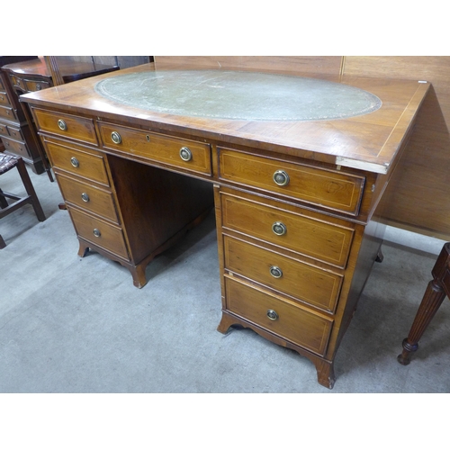 153 - A George III style inlaid yew wood and green leather topped pedestal desk