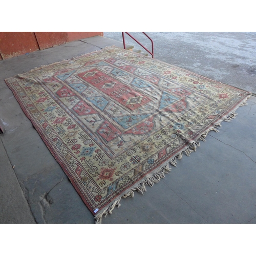 172 - A large Turkish terracotta ground rug, 380 x 290cms