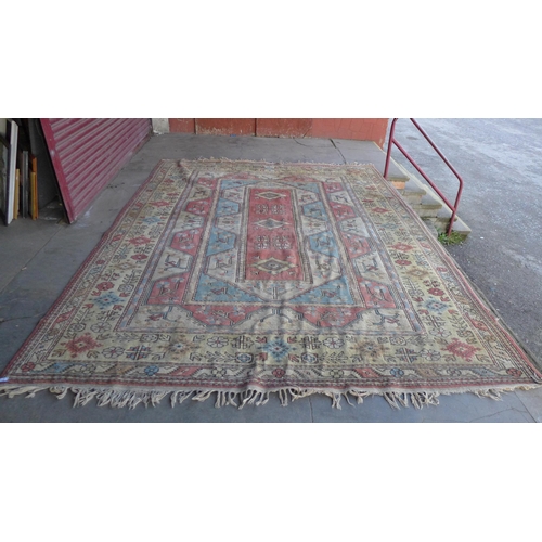 172 - A large Turkish terracotta ground rug, 380 x 290cms