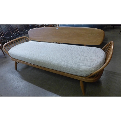 18 - An Ercol Blonde ash and beech 355 model studio couch. Purchased by the vendor from Hopewells, Nottin... 