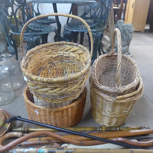 285 - Assorted walking sticks, a warming pan and five wicker baskets