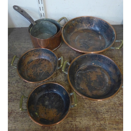 383 - Two small copper saucepans and a set of four copper and brass handled dishes