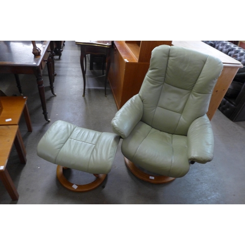 85 - A Norwegian Ekorness Stresless green leather revolving lounge chair and stool