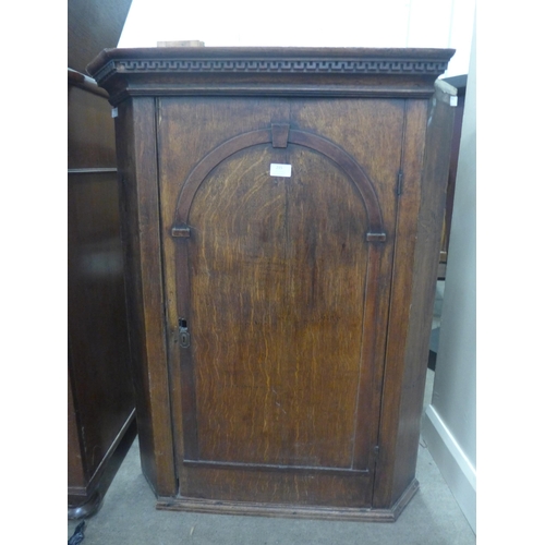 215 - A George III oak wall hanging corner cupboard