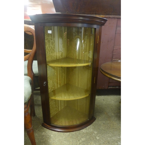 225 - An oval mahogany coffee table and a wall hanging corner cabinet