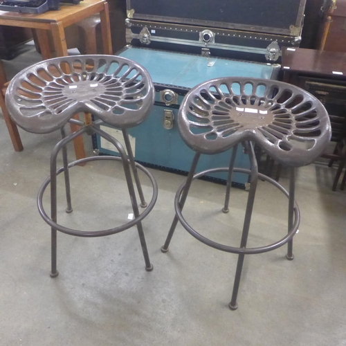 258 - A pair of metal tractor seat revolving stools