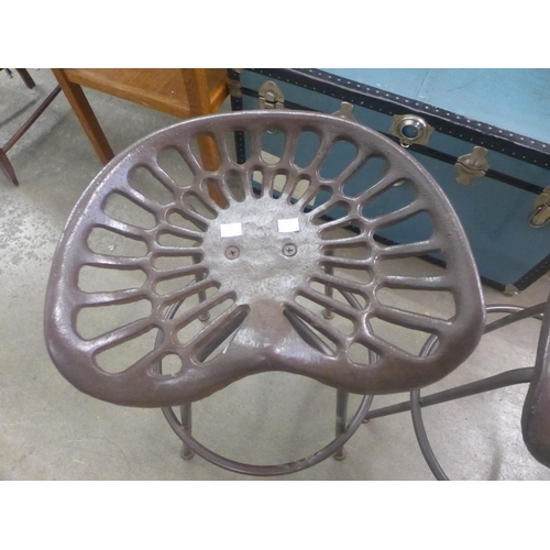 258 - A pair of metal tractor seat revolving stools