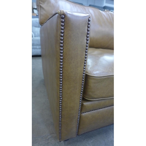 1303 - A tan vintage leather two and a half seater sofa with studwork, RRP £2850 * this lot is subject to V... 