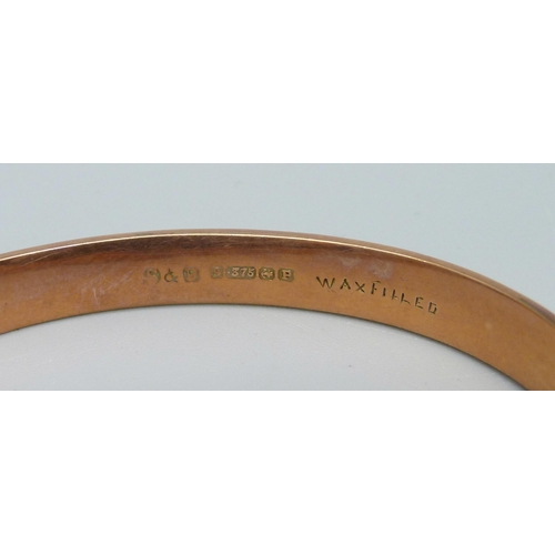 1002 - A 9ct gold bangle, marked 'wax filled', 10.5g