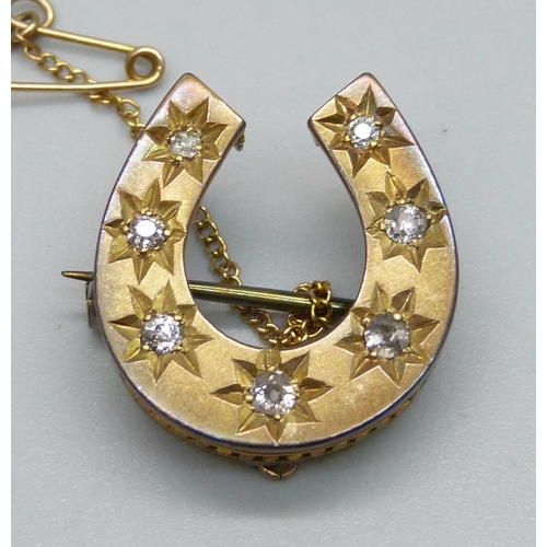 1006 - A yellow metal horseshoe brooch set with seven diamonds, 3.8g, 2.2 x 2cm