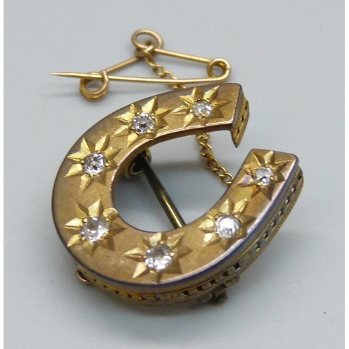 1006 - A yellow metal horseshoe brooch set with seven diamonds, 3.8g, 2.2 x 2cm