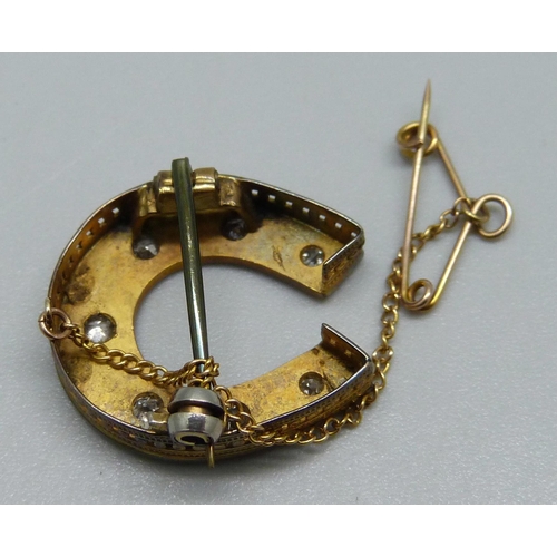 1006 - A yellow metal horseshoe brooch set with seven diamonds, 3.8g, 2.2 x 2cm