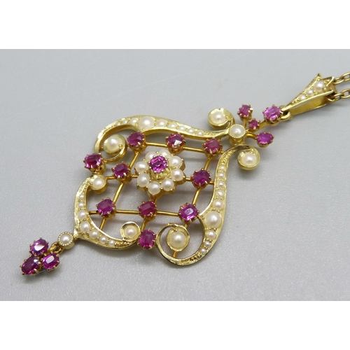 1010 - A 15ct gold Art Nouveau drop pendant set with rubies and seed pearls, 5.8cm including bale and drop,... 