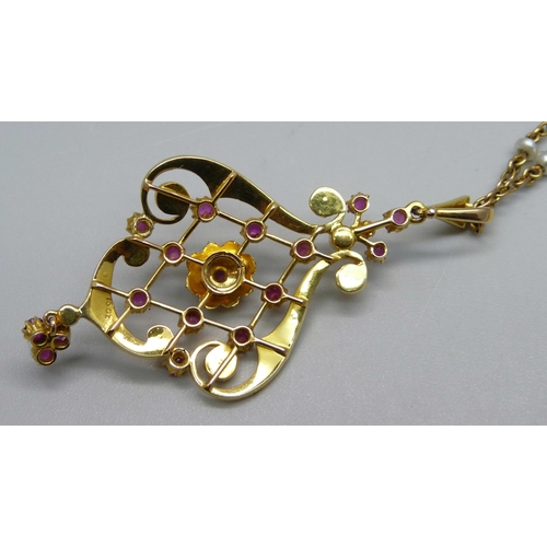 1010 - A 15ct gold Art Nouveau drop pendant set with rubies and seed pearls, 5.8cm including bale and drop,... 