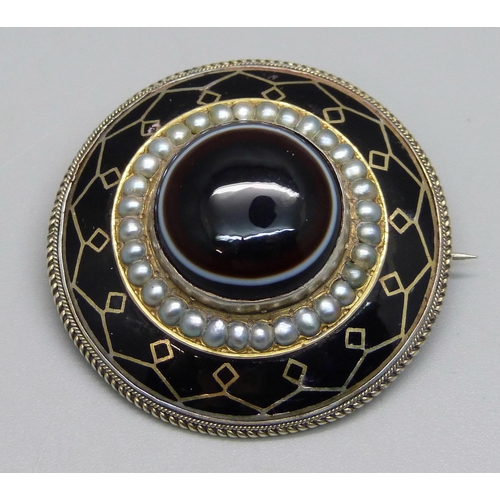 1022 - A Victorian bull's eye agate, seed pearl and enamel mourning brooch, 4.1cm