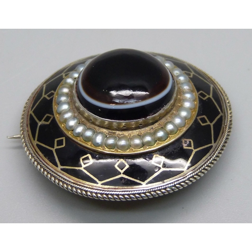 1022 - A Victorian bull's eye agate, seed pearl and enamel mourning brooch, 4.1cm