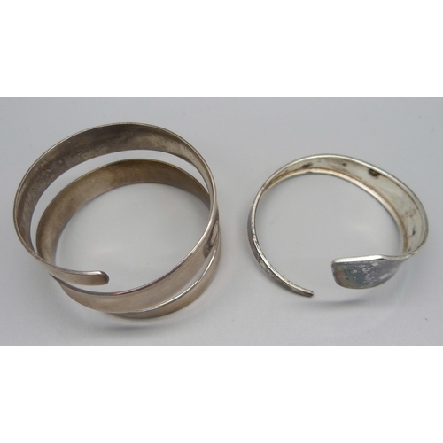 1068 - A silver bangle, 16g and an unmarked white metal bangle, 69g