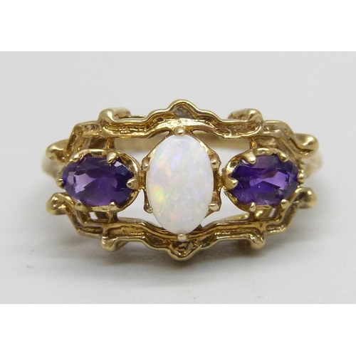 1087 - A 9ct gold ring set with two amethysts and an opal, 2.4g, M