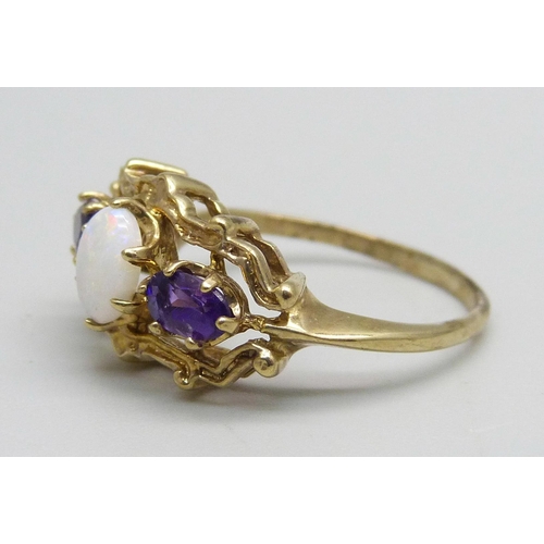 1087 - A 9ct gold ring set with two amethysts and an opal, 2.4g, M