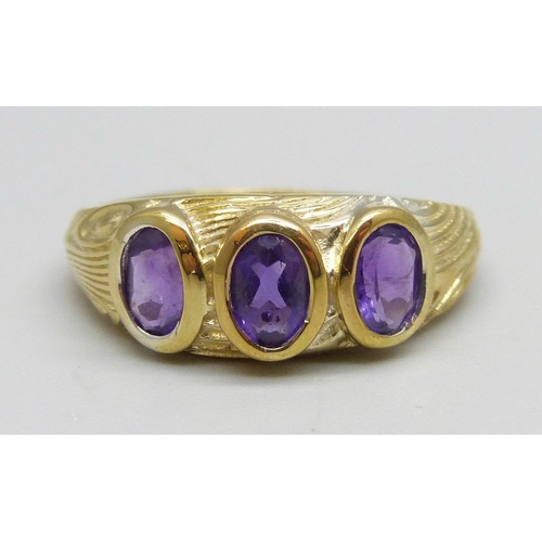 1096 - A silver gilt, three stone amethyst ring, T