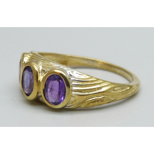 1096 - A silver gilt, three stone amethyst ring, T