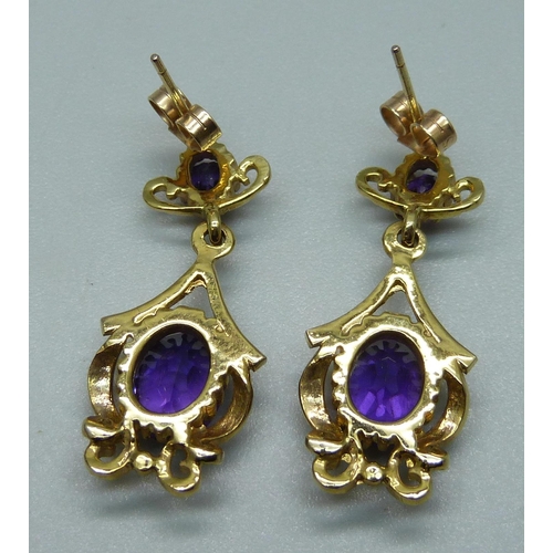 1108 - A pair of 9ct gold and amethyst set drop earrings, hallmarked on the posts, 5.9g, 3cm drop