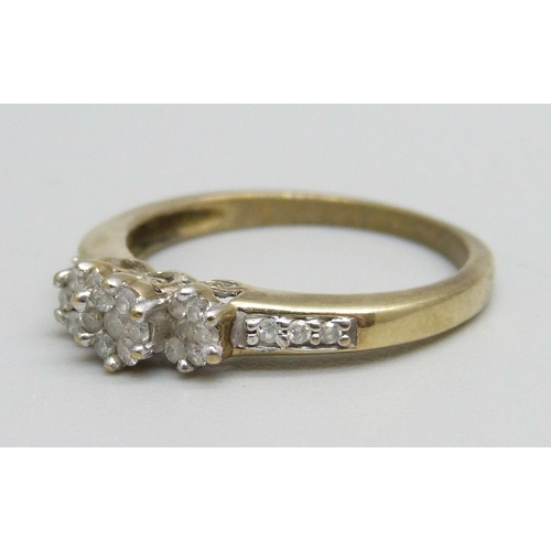 1114 - A 9ct gold ring set with three diamond clusters and diamond shoulders, 2.2g, O