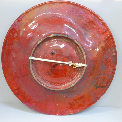 605 - A large early 20th Century red glazed charger, 44.5cm