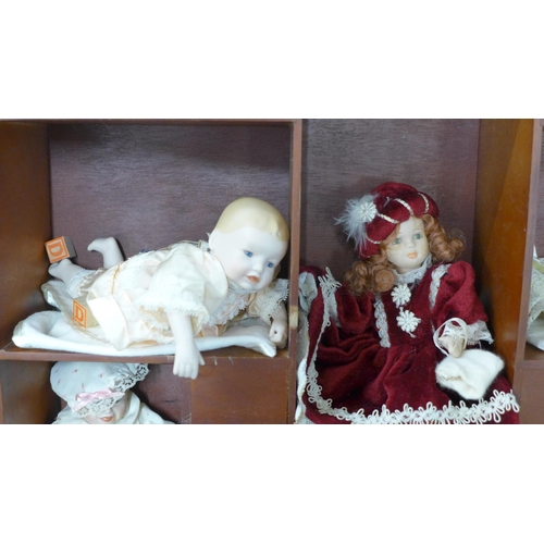 803 - A doll display case with thirteen small china dolls and one other larger doll **PLEASE NOTE THIS LOT... 