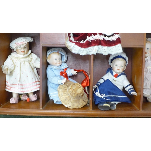 803 - A doll display case with thirteen small china dolls and one other larger doll **PLEASE NOTE THIS LOT... 