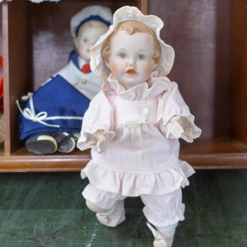 803 - A doll display case with thirteen small china dolls and one other larger doll **PLEASE NOTE THIS LOT... 