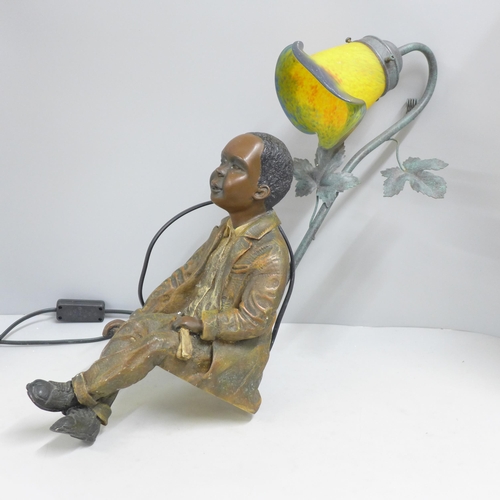 834 - A resin lamp with glass shade, depicting a seated boy