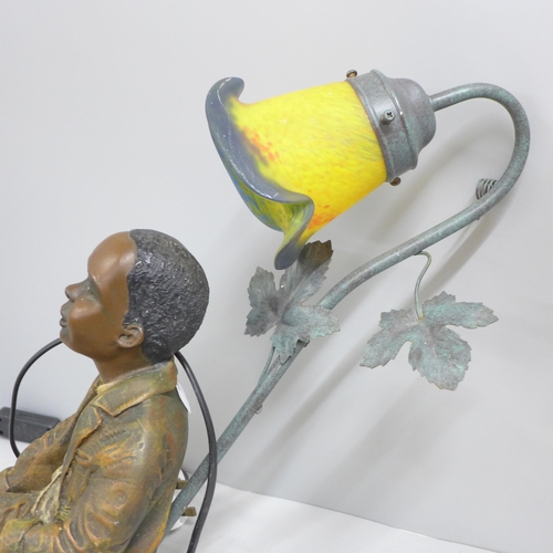 834 - A resin lamp with glass shade, depicting a seated boy