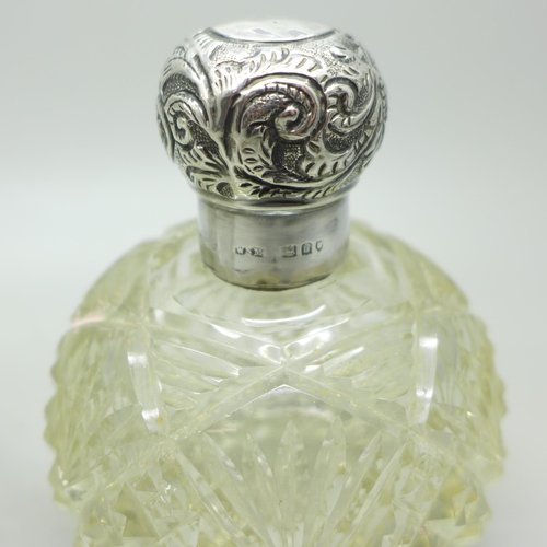 884 - Two silver topped glass scent bottles, one by William Comyns