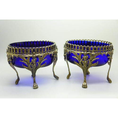 889 - A pair of Victorian silver oval table bon-bon dishes on four feet and with blue glass liners, London... 