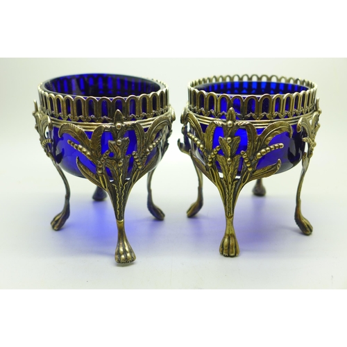 889 - A pair of Victorian silver oval table bon-bon dishes on four feet and with blue glass liners, London... 