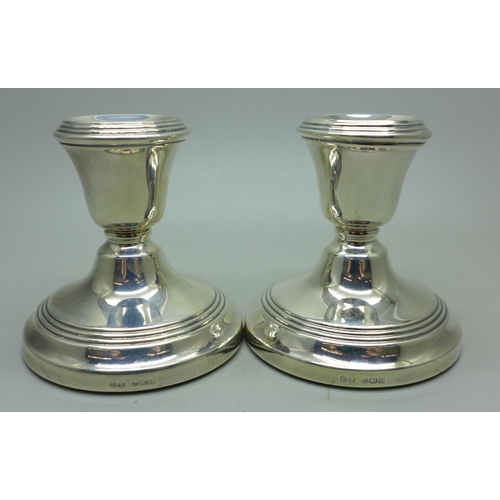 911 - A pair of silver dwarf candlesticks, weighted bases