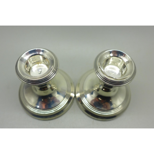 911 - A pair of silver dwarf candlesticks, weighted bases