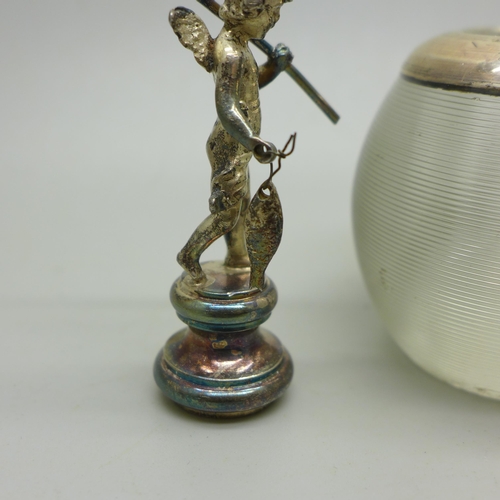 912 - A silver rimmed glass match striker and a small silver winged cherub figure