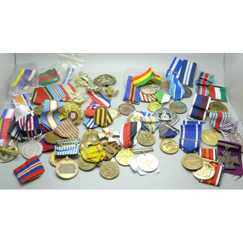 921 - A collection of medals including German, Soviet Union, cap badges and ribbons, (including some repro... 