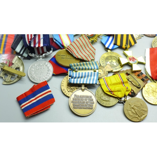 921 - A collection of medals including German, Soviet Union, cap badges and ribbons, (including some repro... 