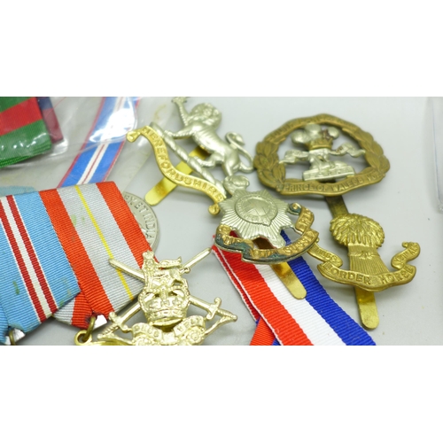 921 - A collection of medals including German, Soviet Union, cap badges and ribbons, (including some repro... 