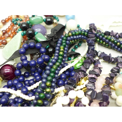 945 - A collection of bead necklaces and bracelets including semi-precious stones, etc.