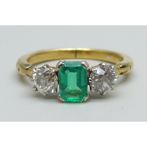 996 - A yellow metal ring set with a central emerald and two diamonds, 3.8g, Q/R, emerald 5mm x 7mm, shank... 