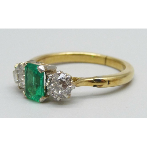 996 - A yellow metal ring set with a central emerald and two diamonds, 3.8g, Q/R, emerald 5mm x 7mm, shank... 