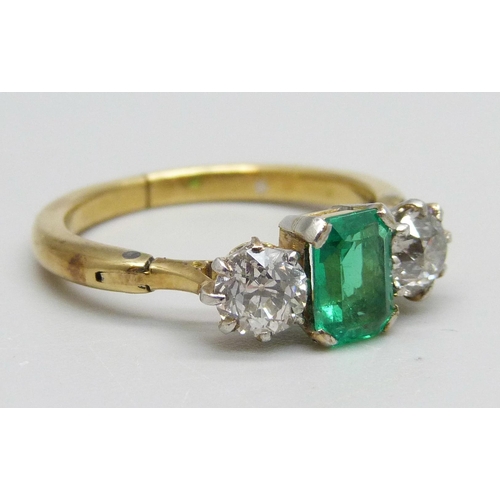 996 - A yellow metal ring set with a central emerald and two diamonds, 3.8g, Q/R, emerald 5mm x 7mm, shank... 