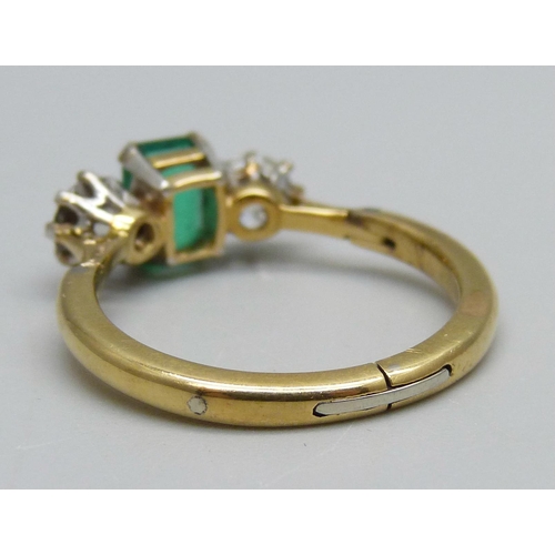 996 - A yellow metal ring set with a central emerald and two diamonds, 3.8g, Q/R, emerald 5mm x 7mm, shank... 