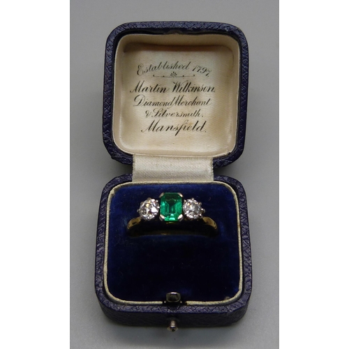 996 - A yellow metal ring set with a central emerald and two diamonds, 3.8g, Q/R, emerald 5mm x 7mm, shank... 