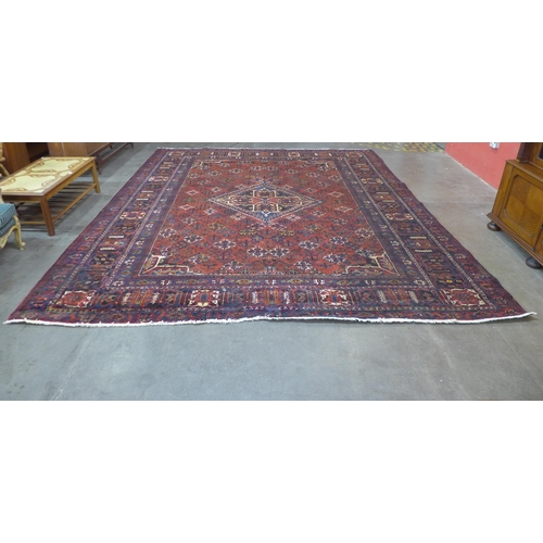 146 - An Iranian red ground rug, 395 x 325cms